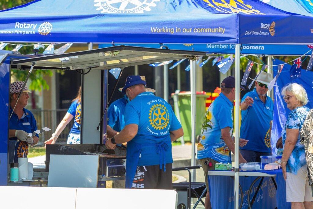 Gruppe von Menschen in blauen Hemden während eines Open-Air-Events im Freien