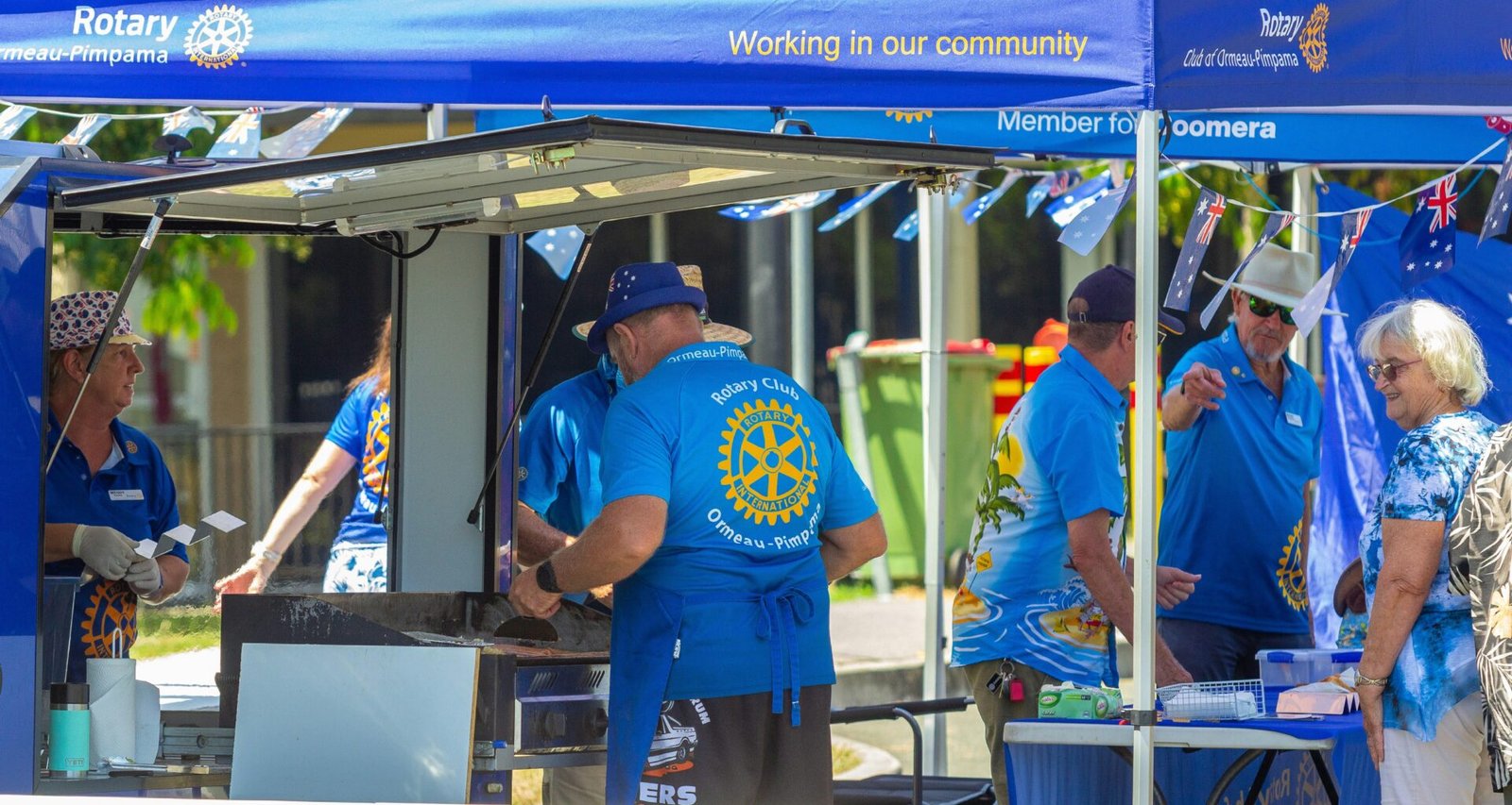 Gruppe von Menschen in blauen Hemden während eines Open-Air-Events im Freien