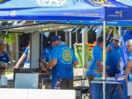 Gruppe von Menschen in blauen Hemden während eines Open-Air-Events im Freien