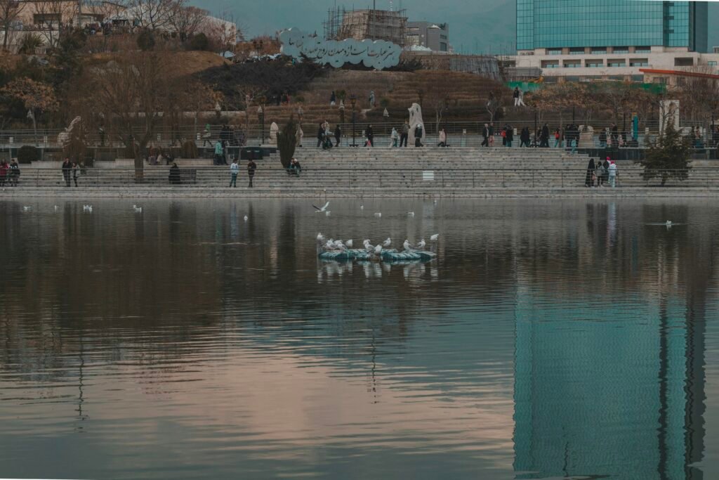Mehrere Menschen in kleinen Booten auf einem ruhigen See, umgeben von Wasser, aufgenommen aus der Ferne.