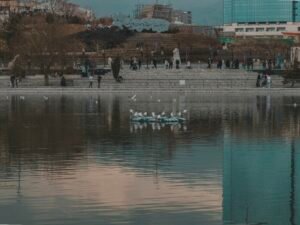 Menschen in kleinen Booten auf einem weitläufigen See, umgeben von Wasser und Natur unter offenem Himmel