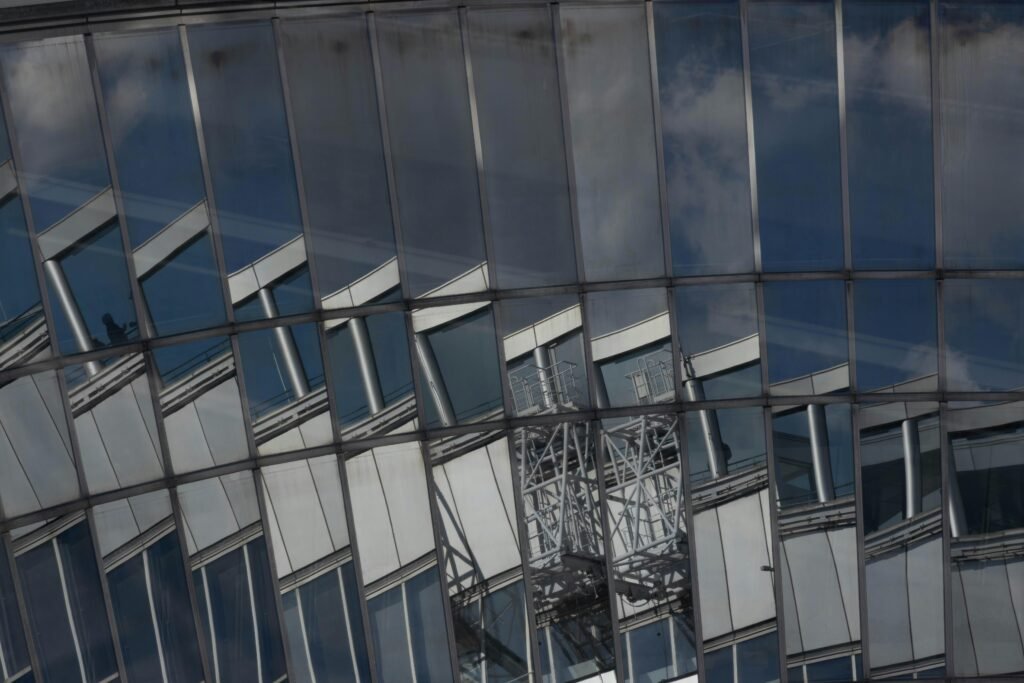 Eine moderne Fassadenansicht eines Gebäudes mit Glasfront und markanten Reflexionen städtischer Umgebung