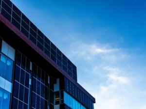Fassade eines modernen Gebäudes mit Solarzellen, die vor einem klaren, blauen Himmel installiert sind
