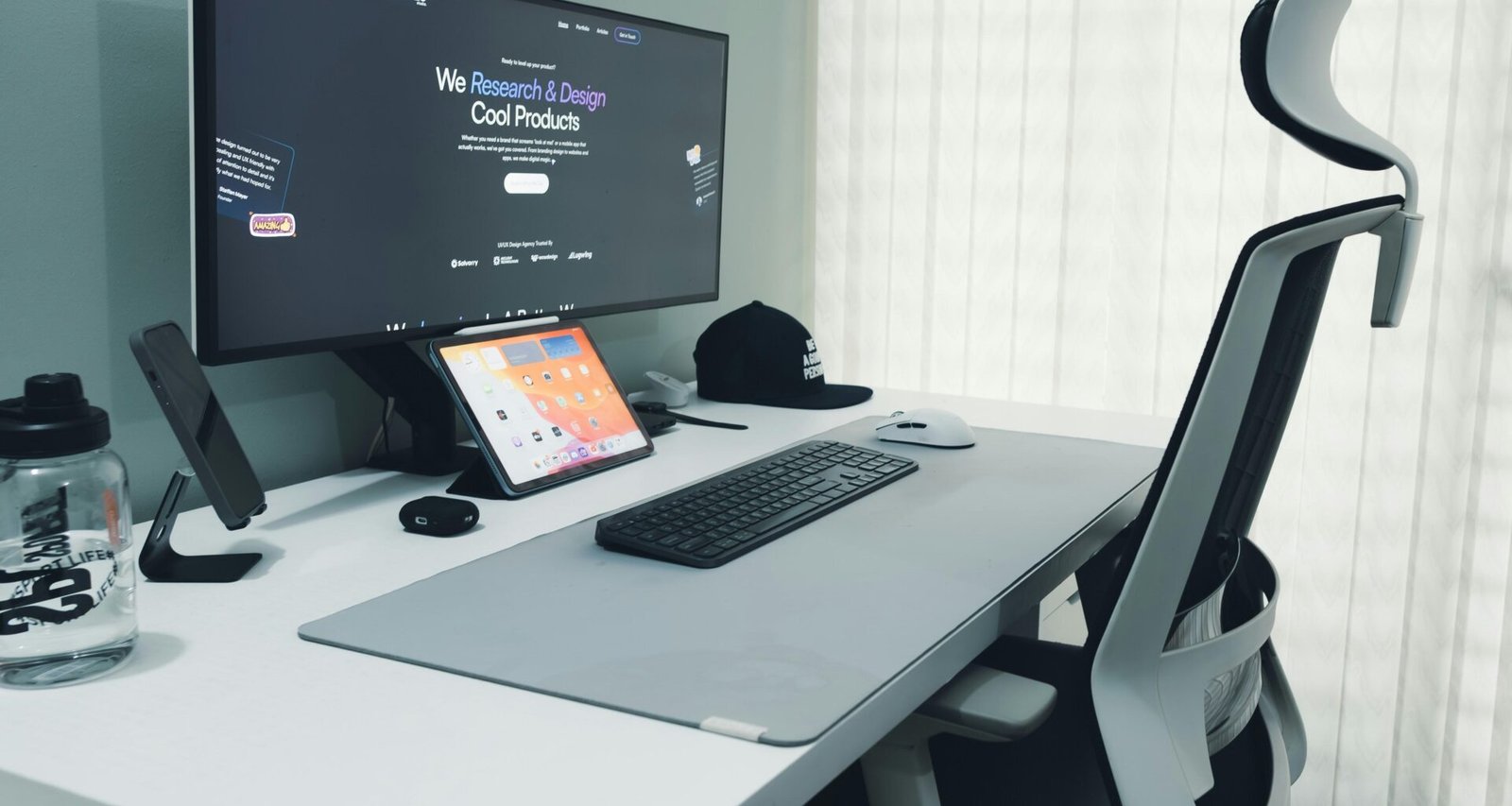 Moderner Schreibtisch mit Computer, ergonomischem Stuhl und minimalistischer Ausstattung in einem hellen Büro.