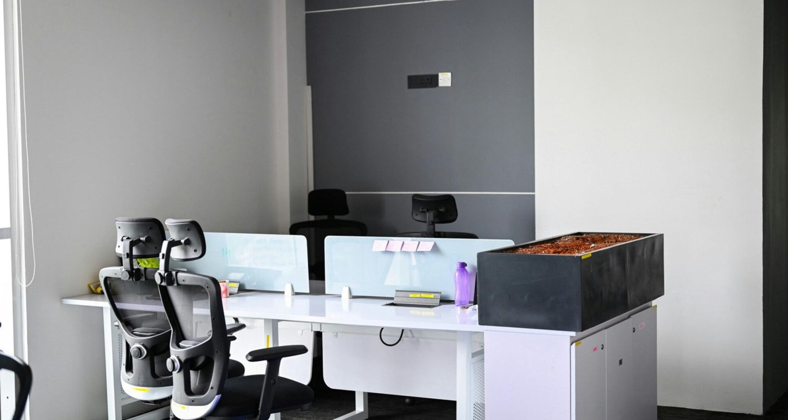 Ein modernes Büro mit mehreren Schreibtischen und Stühlen, geeignet für kollaboratives Arbeiten in Unternehmen oder Agenturen.