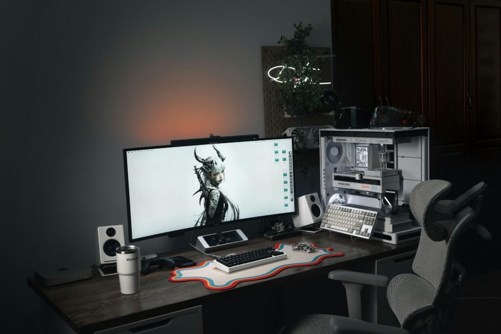 Modernes Computer-Setup mit großem Bildschirm und ergonomischem Gaming-Stuhl an einem Schreibtisch