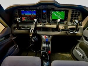 Modernes Flugzeugcockpit mit digitalen Anzeigen und Steuerungen, Fokus auf die technische Ausstattung im Cockpitbereich.