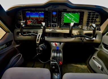 Modernes Flugzeugcockpit mit digitalen Anzeigen und Steuerungen, Fokus auf die technische Ausstattung im Cockpitbereich.