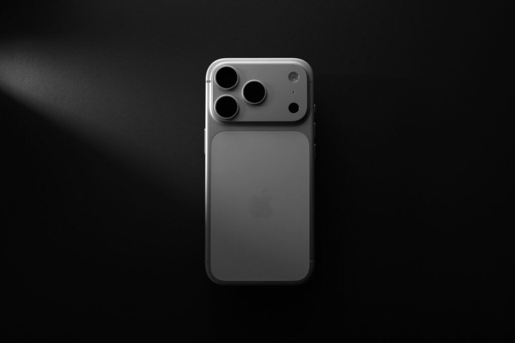 Modernes Smartphone mit drei Kameralinsen auf dunklem Hintergrund, ideal für Technik- und Smartphone-Artikel