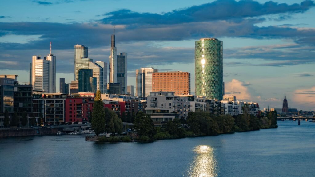 Moderne Skyline mit Hochhäusern an einem Flussufer, Stadtbild mit Bürotürmen, aufgenommen aus der Ferne