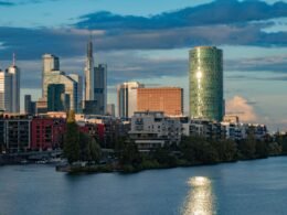 Moderne Skyline mit Hochhäusern an einem Flussufer, Stadtbild mit Bürotürmen, aufgenommen aus der Ferne
