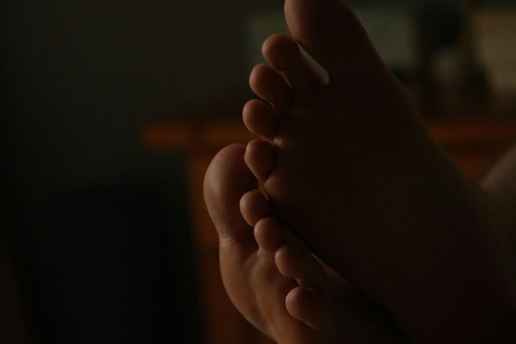 Nahaufnahme von nackten Füßen in gedämpftem Licht, passend für Themen rund um Alltag, Lifestyle oder Gesundheit