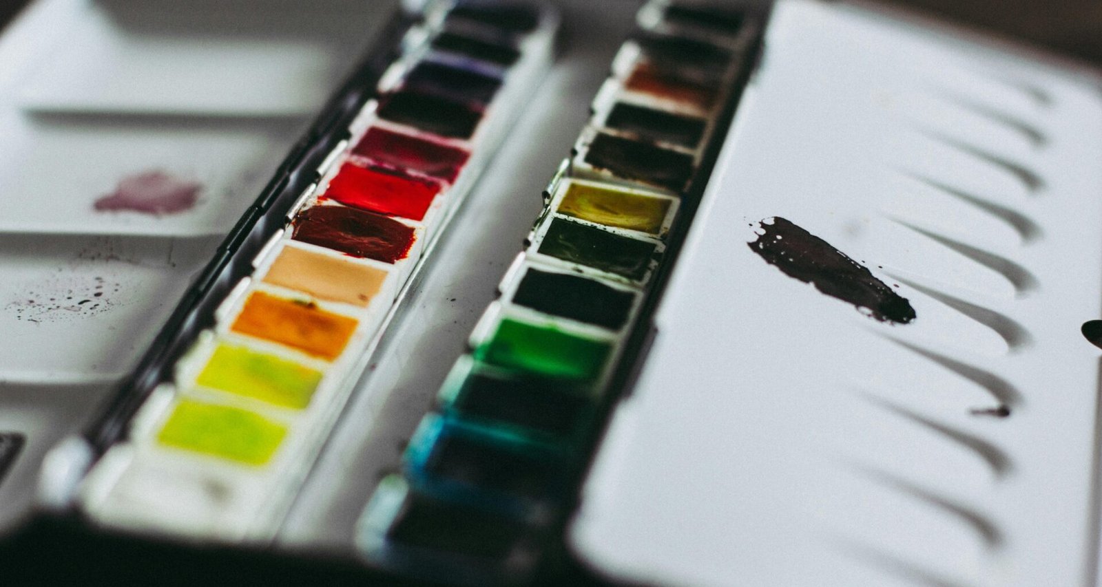 Nahaufnahme einer Farbmischpalette mit verschiedenen Farbtönen, die für künstlerische Arbeiten verwendet werden