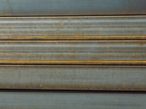 Detailaufnahme einer Metalloberfläche mit sichtbarem Rost und ausgeprägten Strukturveränderungen.