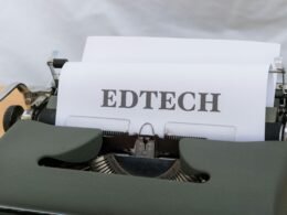 Nahaufnahme einer Schreibmaschine mit eingespanntem Papier, zeigt Details der Tasten und des Papiereinzugs