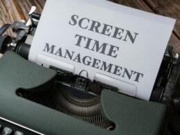 Nahaufnahme einer alten Schreibmaschine mit einem eingeklemmten weißen Zettel, Detailansicht der Tasten und des Papiers