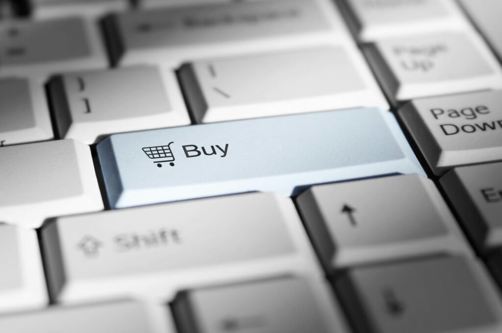Nahaufnahme einer Computertastatur mit hervorgehobener buy-Taste, stellvertretend für Online-Shopping