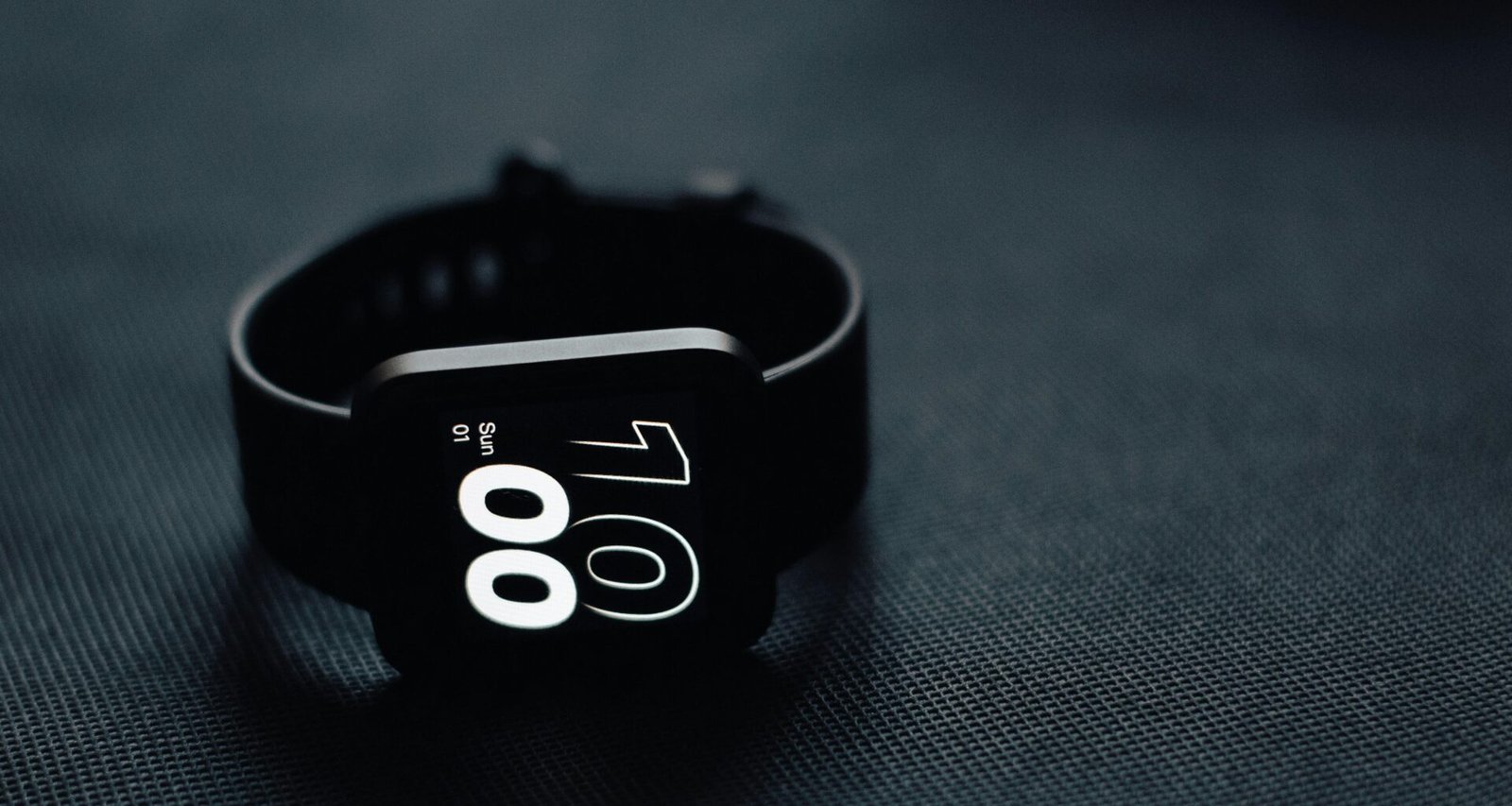 Nahaufnahme einer silbernen Armbanduhr, die auf einer hellen Tischoberfläche liegt, Fokus auf das Ziffernblatt.