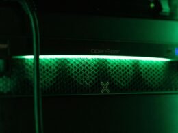 Nahaufnahme einer grünen Kontrollleuchte an einem Server in einem Rechenzentrum mit Fokus auf technische Details