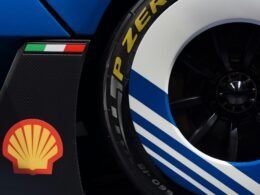 Nahaufnahme eines Rennwagenrads mit prominentem Shell-Logo auf der Felge und klar sichtbaren Details.
