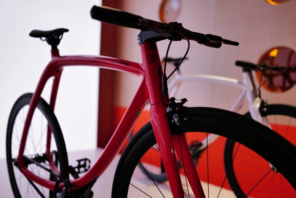 Rotes Fahrrad in einem hellen Raum, modernes Design und Fokus auf das Vorderrad, aufgenommen aus der Nähe