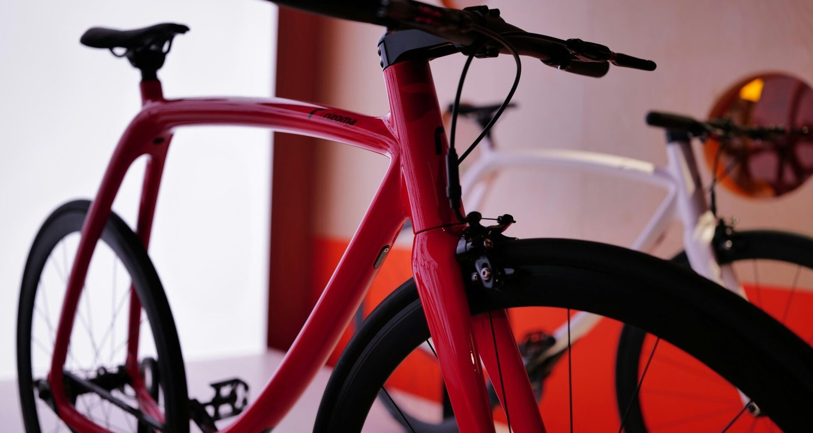 Rotes Fahrrad in einem hellen Raum, modernes Design und Fokus auf das Vorderrad, aufgenommen aus der Nähe