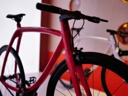 Rotes Fahrrad in einem hellen Raum, modernes Design und Fokus auf das Vorderrad, aufgenommen aus der Nähe