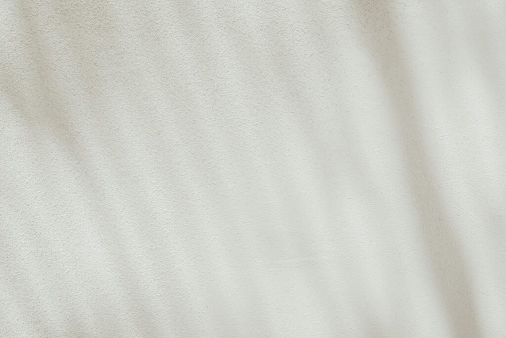 Detailreiche Nahaufnahme eines weißen Stoffes mit deutlicher Stoffstruktur und feinem Gewebe