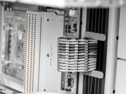 Nahaufnahme von Komponenten in einem Computer-Serverrack mit sichtbaren Kabeln und Hardwareelementen