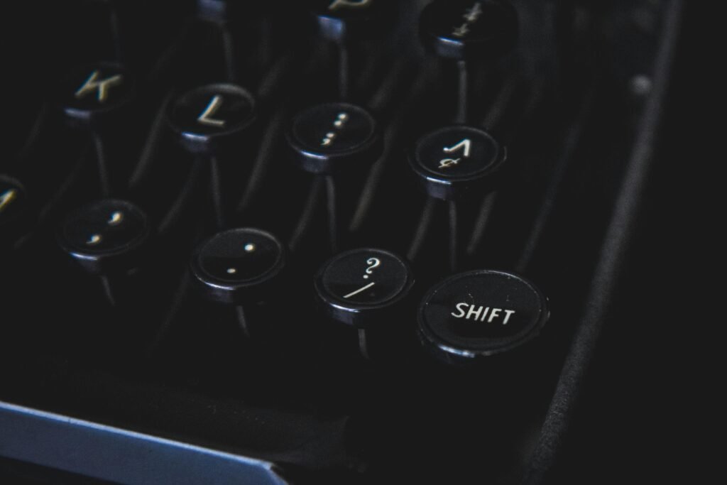 Detailansicht von klassischen Schreibmaschinentasten mit Fokus auf das Tastaturlayout vor schwarzem Hintergrund