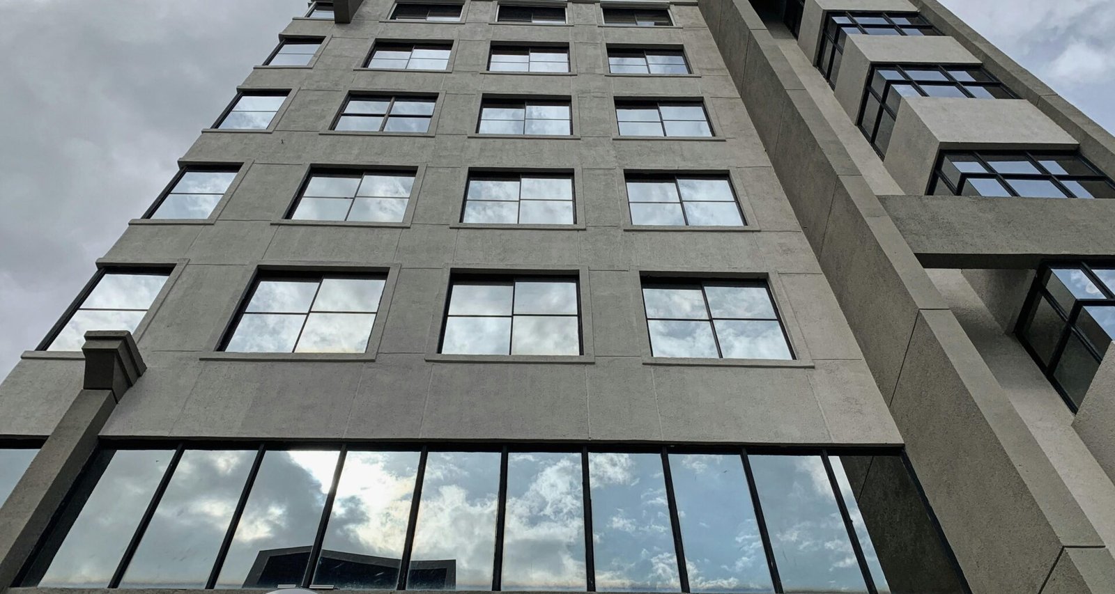 Niedrigwinkelaufnahme eines braunen Betongebäudes mit Betonfassade und klaren Linien