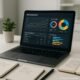 Moderner Arbeitsplatz mit Laptop, SEO-Analyse-Dashboard, Notizbüchern, Stift und Topfpflanze in hellem Büro