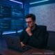 Futuristisches Arbeitszimmer mit mehreren Monitoren, Whiteboards mit Skizzen und eine Person mit stylischem Laptop, umgeben von leuchtenden LED-Lichtern und innovativer Technik.