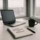 Moderner Schreibtisch mit handgeschriebenem Notizbuch, Laptop, Stift und Kaffeetasse vor großen Fenstern mit horizontalen Rollos, Tageslicht fällt herein