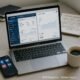Moderner Büroarbeitsplatz mit Laptop, Smartphone, Kaffeetasse und Notizbüchern, die Content-Strategien skizzieren, im Hintergrund.