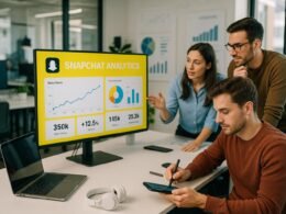 Modernes Büro mit Snapchat-Analysen, Teammitgliedern und technologischen Gadgets, die Daten diskutieren, bei Tageslicht beleuchtet, vermittelt Fokus und Innovation.