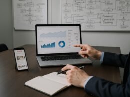 Professioneller Arbeitsplatz mit Laptop, Smartphone und Whiteboards, zeigt Datenanalysen und Pinterest-Kampagnen, Bild von Tobias Hager für 404 Magazine