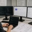 Moderne Arbeitsstation mit mehreren Bildschirmen, Entwickler überprüft Pull-Request, umgeben von technischen Diagrammen und SEO-Analysen im Büro