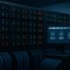 Moderner Serverraum mit horizontalen Racks, blinkenden LEDs, Netzwerkkabeln und Monitor, der Sicherheits- und Automatisierungstools anzeigt
