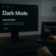 Moderner Arbeitsplatz mit Dark Mode Webseite, CSS-Code auf Laptop, technische Diagramme an der Wand, fotografiert von Tobias Hager, 404 Magazine.