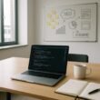 Modernes, sachliches Büro mit Laptop, Notizbuch, Kaffee und Pinnwand mit Sticky Notes und SEO-Diagrammen, Tageslicht durch große Fenster, professionelle Arbeitsumgebung.