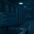 Moderner Serverraum mit blauen und grünen Beleuchtungen, Monitor mit Code und schematischen Datenflussübersichten