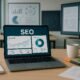 Moderner Arbeitsplatz mit Laptop, Notizblättern, Kaffee und Whiteboards mit Seo-Statistiken, professionelles und technikorientiertes Ambiente