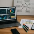 Moderner Arbeitsplatz mit Laptop, gedruckten Keyword-Daten, Whiteboard mit SEO-Diagrammen und grüner Pflanze
