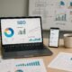 Moderner Arbeitsplatz mit Laptop, Analytics-Berichten, Smartphone, Kaffee und Whiteboard zur Website-Optimierung, Bildcredit: 404 Magazine (Tobias Hager)