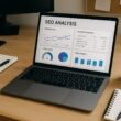 Moderner Arbeitsplatz mit Laptop, Notizblöcken, Kaffee und technischen Geräten, die SEO-Analysen mit kostenlosen Tools zeigen