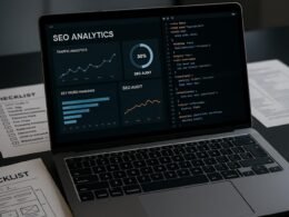 Nahaufnahme eines modernen Laptops mit SEO-Analyse-Dashboards, Diagrammen und Codeseiten, umgeben von Checklisten und technischen Schaltplänen auf einem Schreibtisch