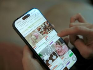 Eine Person scrollt auf einem Smartphone durch eine Online-Shopping-App und betrachtet Produktangebote.