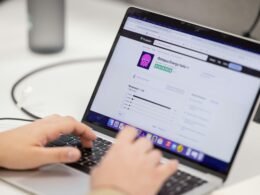Nahaufnahme einer Person, die auf einem Laptop-Computer tippt – Symbol für digitale Arbeit und Online-Marketing.