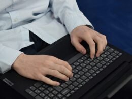 Nahaufnahme einer Person, die auf einer Laptop-Tastatur tippt, Symbol für digitale Arbeit im modernen Büroalltag